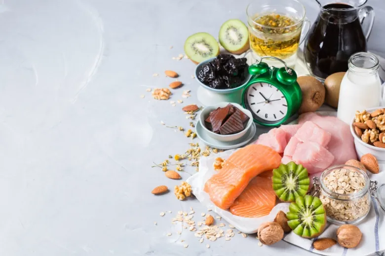 mix of foods on table with a clock among them