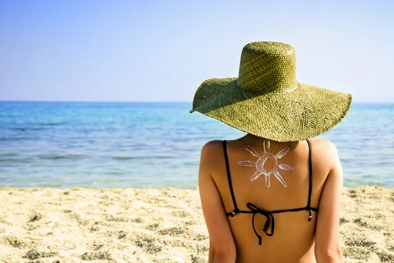 women sitting on a beach in a hat